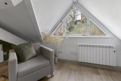 a living room with a chair and a window at 4A The Courtyard, City Centre Apartment, Exeter in Exeter