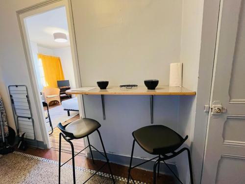 - une cuisine avec deux tabourets et un comptoir avec deux bols dans l'établissement Casa Gare, à Angers
