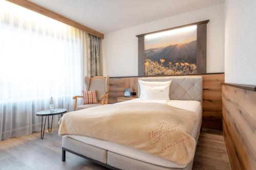 a hotel room with a bed and a window at Hotel Tyrol - Oberstaufen PLUS Partner in Oberstaufen