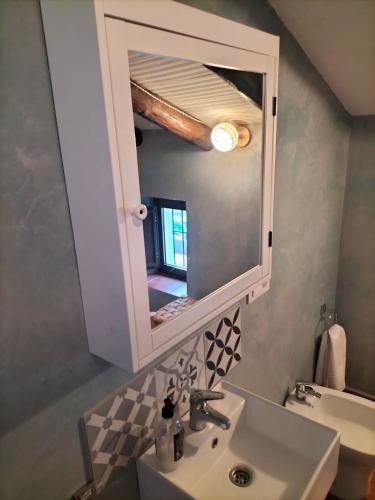 a bathroom with a sink and a mirror at Cortijo Rural El Contador, con chimenea in Constantina