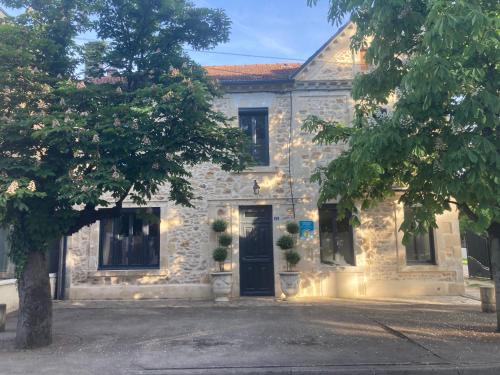 a stone house with a door and a tree at La Maison du Parc 47 in Fumel