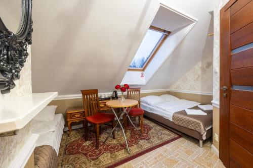 a small room with a bed and a table at Dworek Kurowski in Szczecin