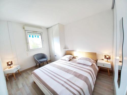 une chambre blanche avec un lit et une chaise dans l'établissement 500m de la Mer- 4pers-Piscine-Parking-WiFi- Clim, à Fréjus