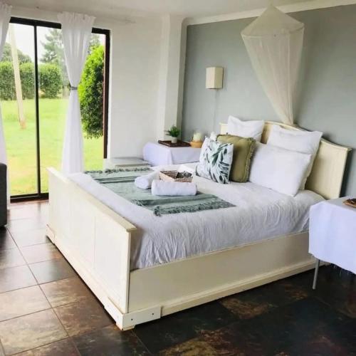 a large white bed in a room with a window at Buckswood Hilltops in Stegi