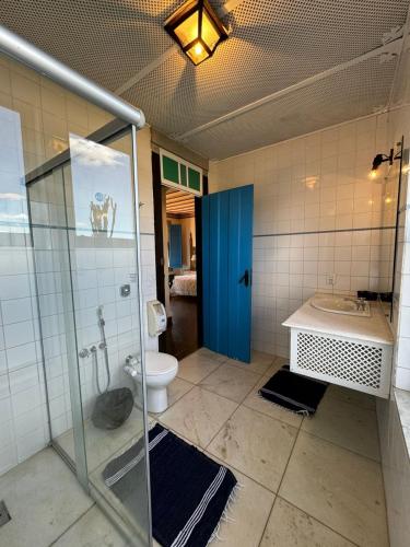 a bathroom with a shower and a toilet and a blue door at Pousada Paço do Lavradio in São João del Rei