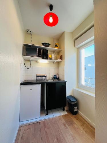 Il comprend une cuisine équipée d'un comptoir noir et d'un réfrigérateur blanc. dans l'établissement Casa Maillé, à Angers