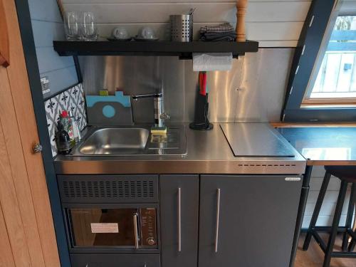 a small kitchen with a sink and a stove at Riverside Pod, West Highland Way Holidays in Kinlochleven