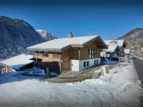 a house in the snow with mountains in the background at Chalet Lula - OVO Network in Châtel