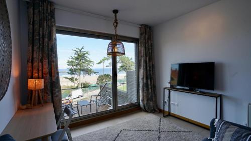 ein Wohnzimmer mit einem großen Fenster und einem TV in der Unterkunft Casa Del Mar in San Vicente de la Barquera