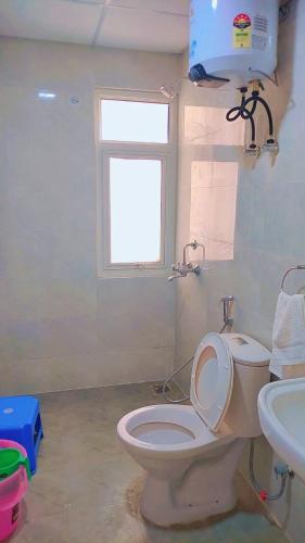 a bathroom with a toilet and a sink and a window at Best for Mahakumbh 2025! in Prayagraj