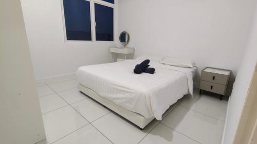 Un dormitorio blanco con una cama con un objeto negro. en No 17 The Sten Puchong IOI Mall, en Puchong