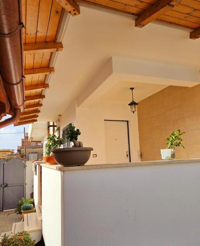 an outdoor kitchen with potted plants on a wall at Oasi di Greta Suite Home - Fiumicino in Fiumicino