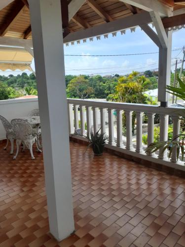 a porch with a table and chairs on a balcony at La SAISONNIERE RELAIS in Le Gosier
