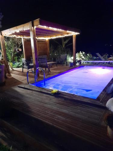 a swimming pool at night with a pergola at La case d'Édith in Le Tampon