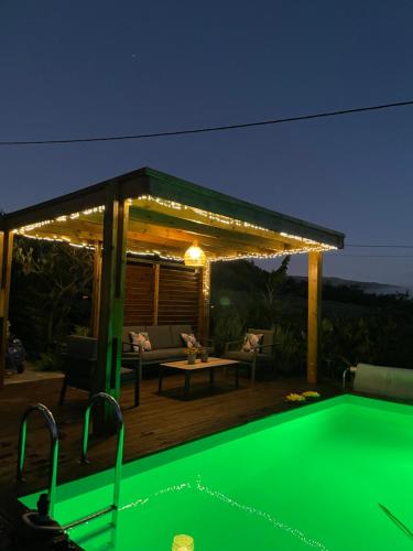 a backyard with a pool and a pergola at night at La case d'Édith in Le Tampon
