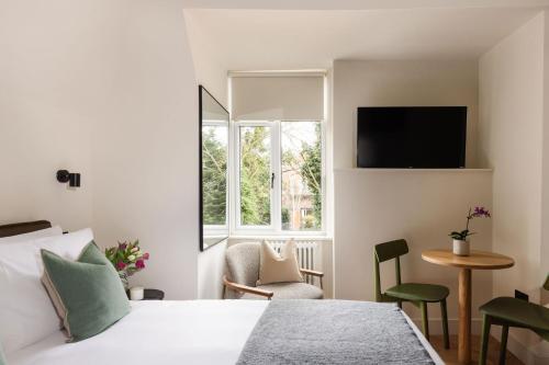 una habitación de hotel con una cama y una ventana en FiveM West Hampstead - North, en Londres