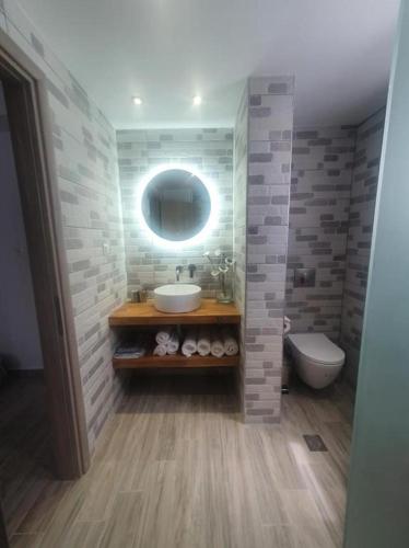 a bathroom with a sink and a toilet and a mirror at Angelica Residence in Gennadi