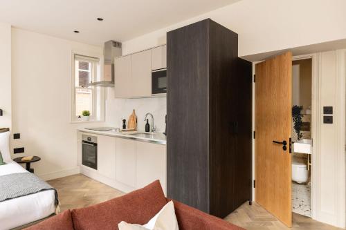una cocina con una puerta que da a una sala de estar. en FiveM West Hampstead - North, en Londres