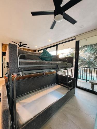 two bunk beds in a room with a ceiling fan at Artistic Loft Steps from the Beach with Pool View in Holbox Island