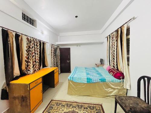 a bedroom with a bed and a desk in it at Prayag Homestays Ada in Prayagraj
