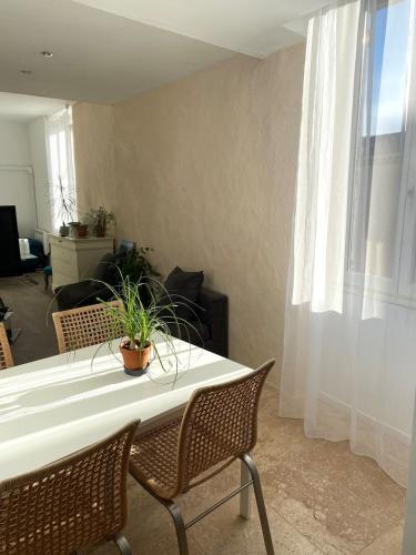 un salon avec une table et des chaises blanches dans l'établissement Ideal pour decouvrir nimes et le gard, à Caveirac