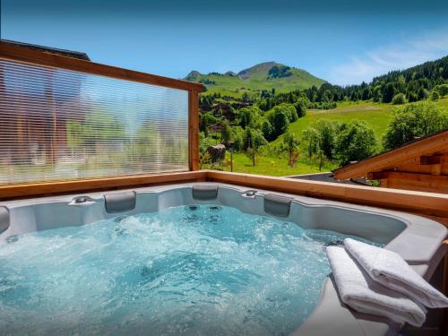 une baignoire jacuzzi avec vue sur les montagnes dans l'établissement Chalet Trusquin - OVO Network, au Grand-Bornand