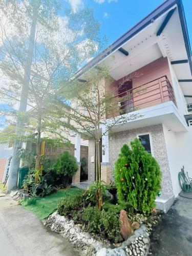 a white house with a tree in front of it at Asuncion Staycation and House rental in San Pablo