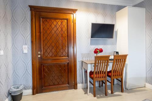 a dining room table with two chairs and a wooden door at Dworek Kurowski in Szczecin