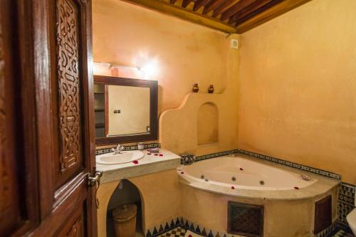 a bathroom with a tub and a sink at Riad - Dar Al Andalous in Fès