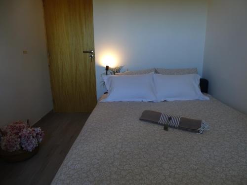 a bedroom with a bed with a book on it at CASA DO POMAR by Stay in Alentejo in Vila Nova de Milfontes