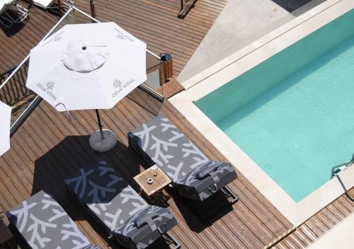 Olive Villas Beach Hotel في سوزوبول: إطلالة علوية على فناء فيه مظلة ومسبح