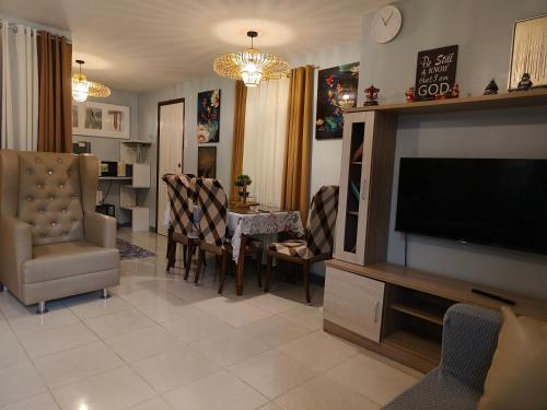 a living room with a television and a dining room at Asuncion Staycation and House rental in San Pablo