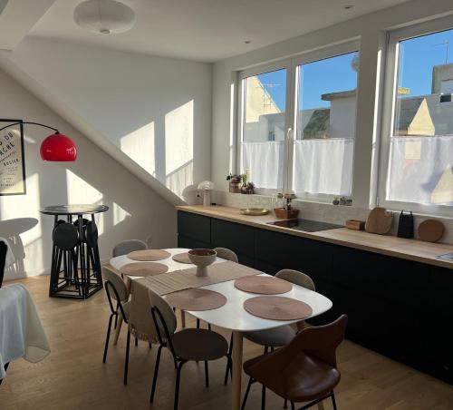 une salle à manger avec tables, chaises et fenêtres dans l'établissement Grand Chelem 2, à Le Touquet-Paris-Plage