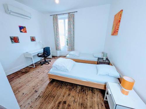 une chambre avec un lit, un bureau et une chaise dans l'établissement Maison et Appartements d'Anatole France proche Centre-Ville, Université - CHU, Patinoire et Futuroscope, à Poitiers