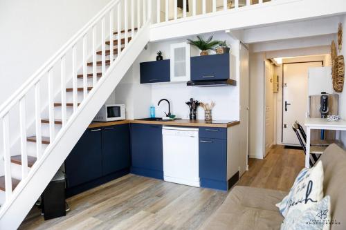 une cuisine avec des armoires bleues et un escalier dans l'établissement Les Voiles Bleues - Appartement Vue Mer et Plage, à Leucate-Plage