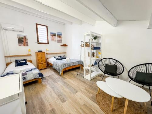 une chambre avec deux lits et une table et des chaises dans l'établissement Les Voiles Bleues - Appartement Vue Mer et Plage, à Leucate-Plage