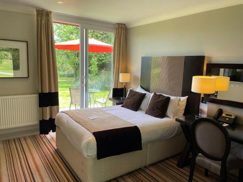 a bedroom with a bed and a desk and a window at Hartsfield Manor in Dorking
