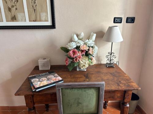 a wooden table with a vase of flowers and a television at Palazzo Contelori in Terni