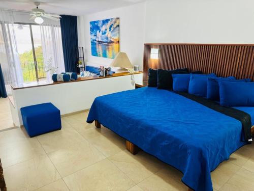 a bedroom with a large blue bed in a room at Palma Real vista al mar in Manzanillo