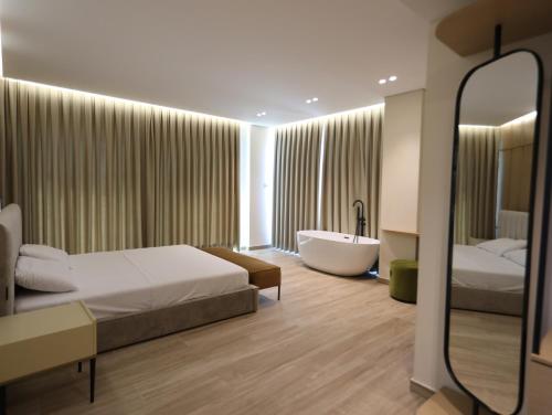 a hotel room with a bed and a bath tub at Avenue Hotel in Ksamil