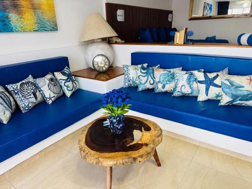 un canapé bleu avec des oreillers et une table dans l'établissement Palma Real vista al mar, à Manzanillo