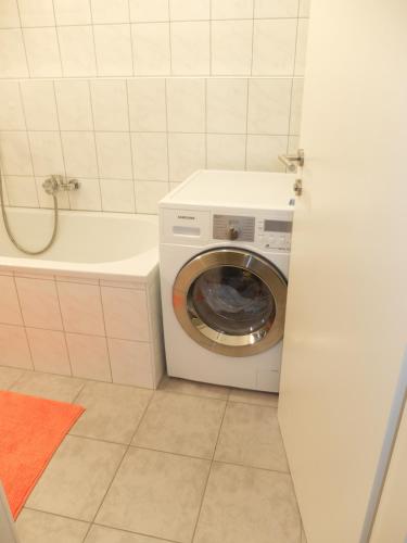 - un lave-linge dans la salle de bains à côté d'une baignoire dans l'établissement Obertauern Fewo Freya by Kamper, à Obertauern