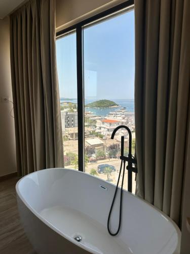 a bath tub in a room with a large window at Avenue Hotel in Ksamil