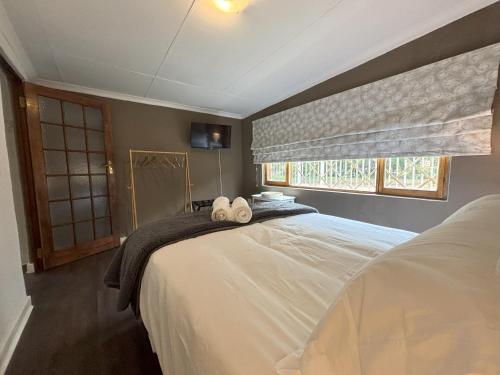 ein Schlafzimmer mit einem Bett mit zwei Handtüchern darauf in der Unterkunft Heartstone's Rest Cottage in Fouriesburg