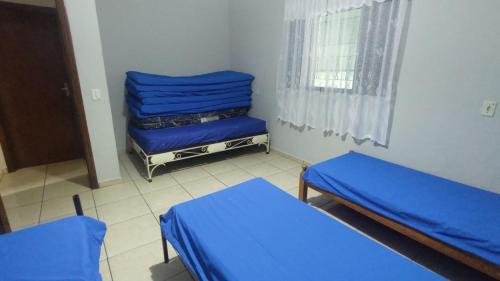 Habitación con 2 camas y sábanas azules. en Chácara do sossego, en Tietê