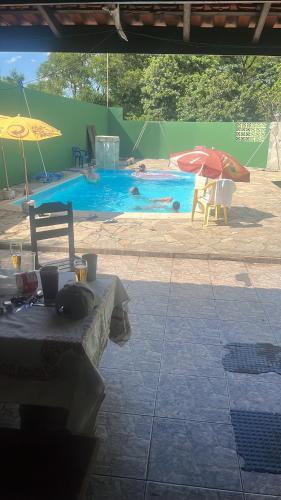 - Piscina con mesa y sombrilla en Chácara do sossego, en Tietê