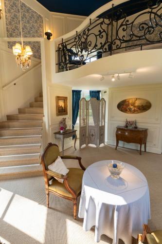 a living room with a table and a staircase at La Folie in Modave