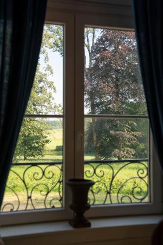 an open window with a view of a yard at La Folie in Modave