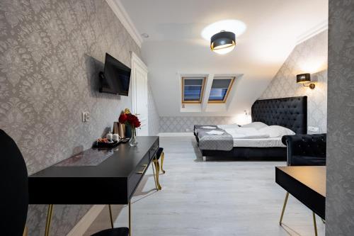 a hotel room with a bed and a living room at Dworek Kurowski in Szczecin