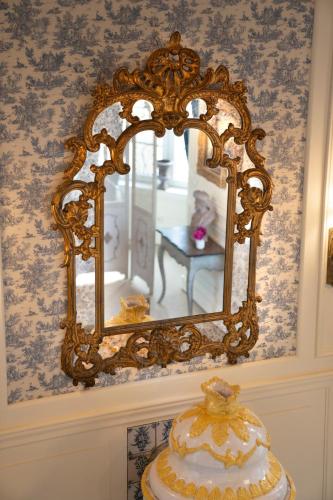 a mirror on a wall above a table with a cake at La Folie in Modave